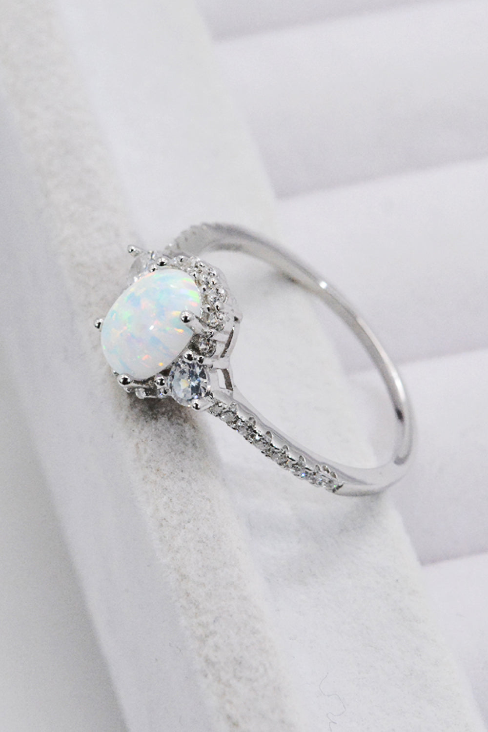 Iridesse™ oval opal cabochon with petite pavé halo and slender stone-set band
