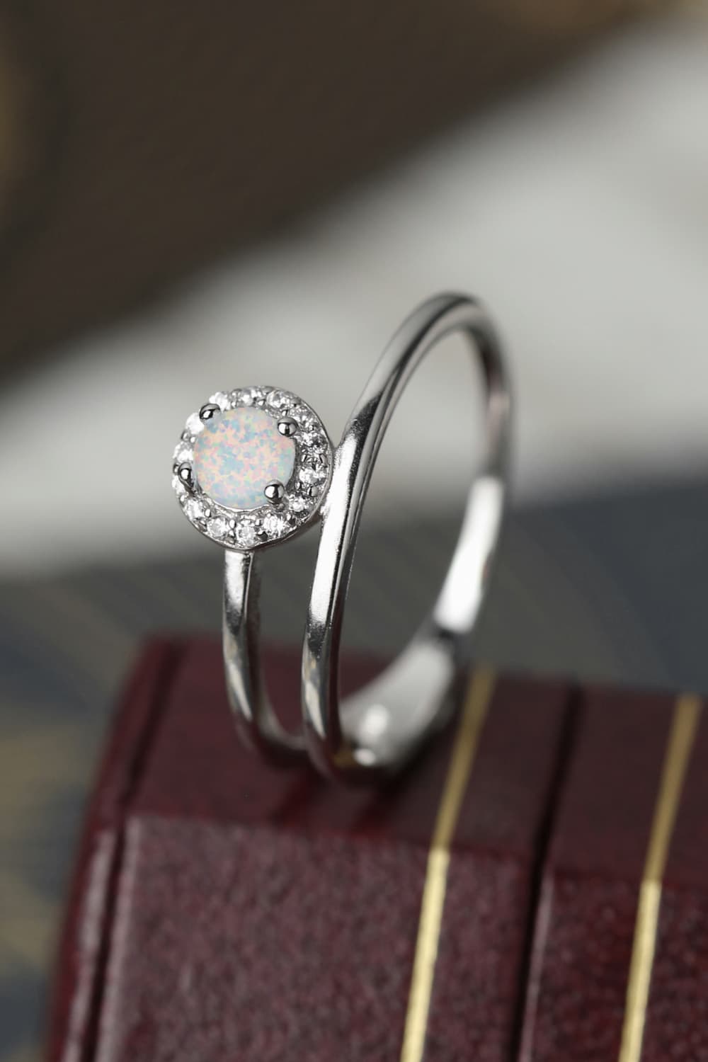 Side profile of a white opal solitaire showing prongs and gallery detail.