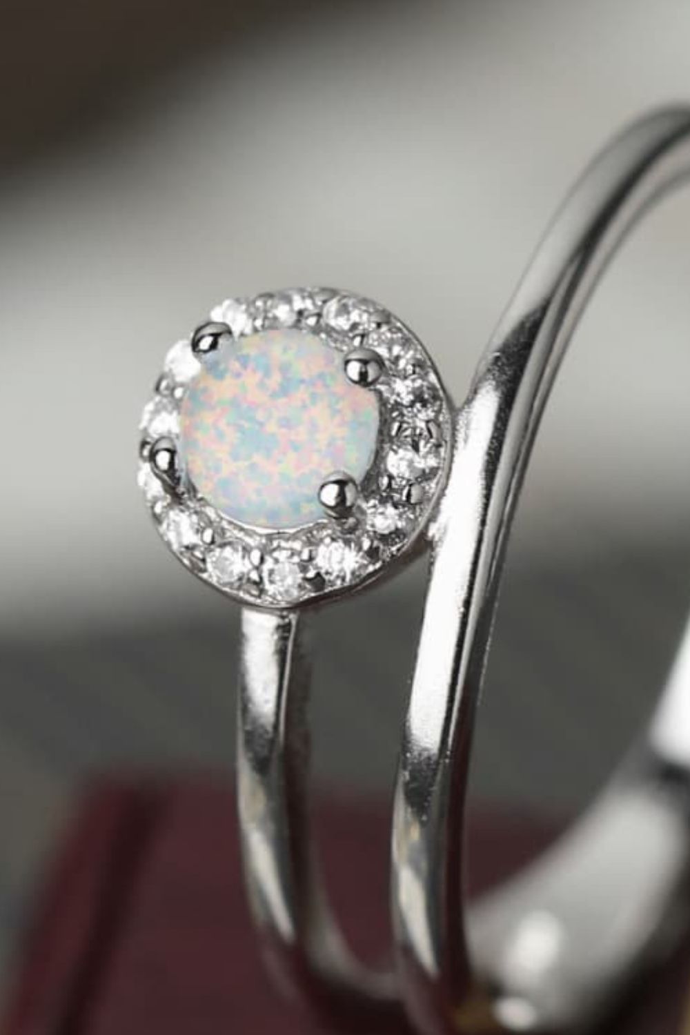 Side profile of a white opal solitaire showing prongs and gallery detail.