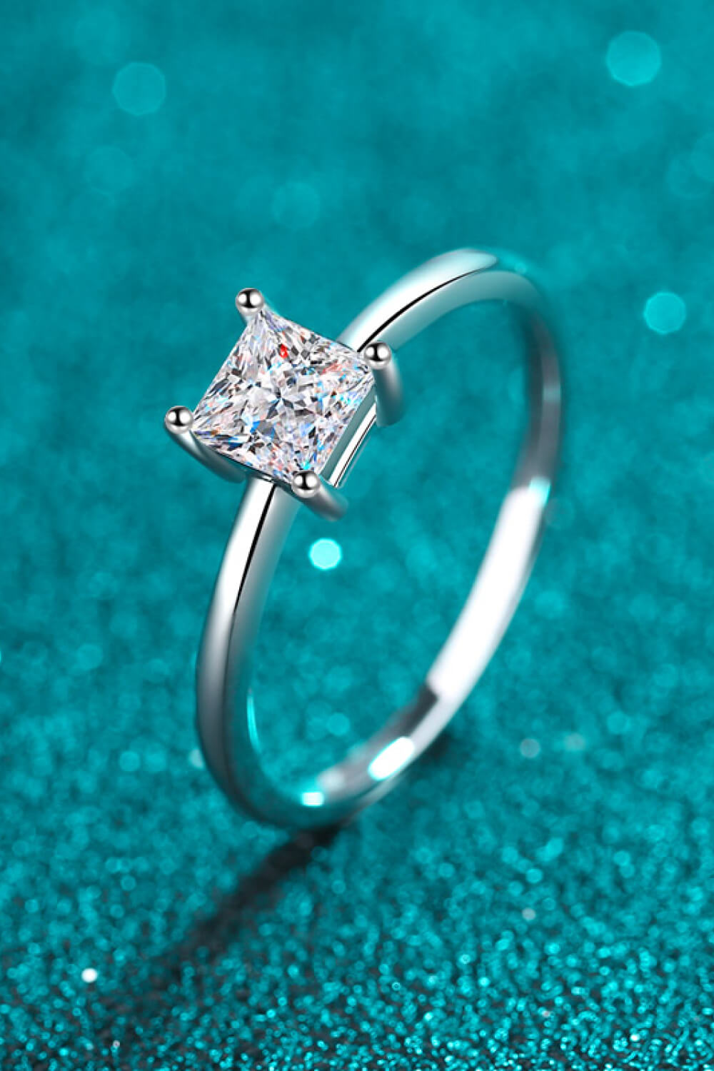 Auren™ princess-cut moissanite ring in platinum-plated 925 sterling silver with minimalist band, styled in modern chic photography.