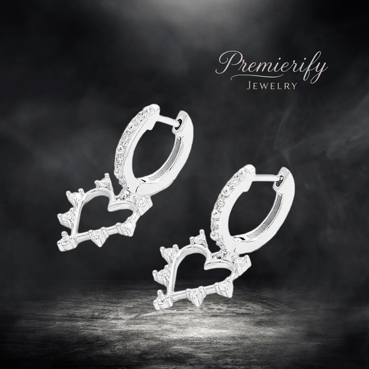 Heart-shaped silver earrings with sparkling stones on a dark background, featuring the 'Premierify Jewelry' brand.
