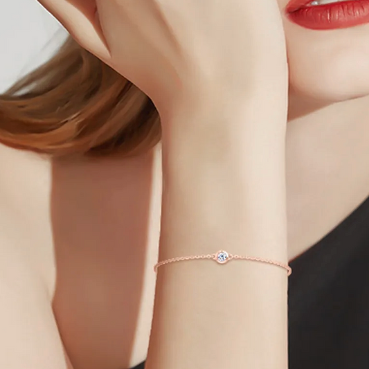 Rose gold bracelet on a person's wrist with a blurred background