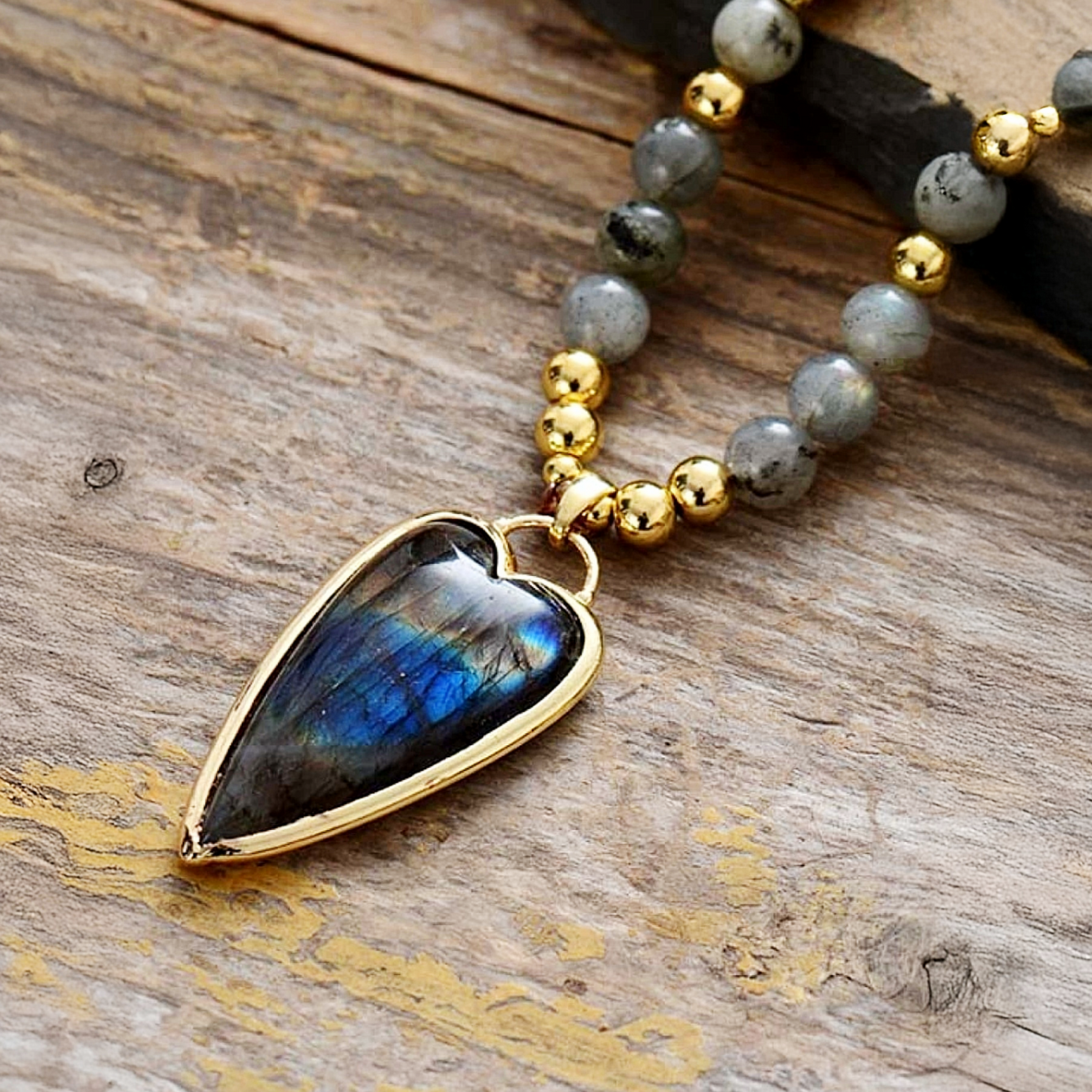 Bracelet with labradorite stone and gold beads on a wooden surface