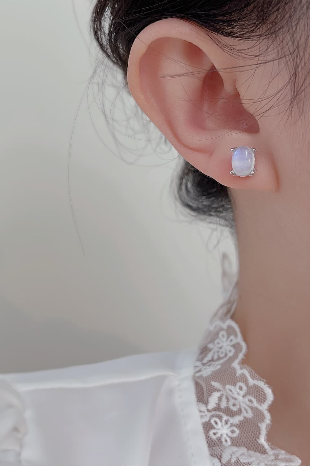 Person wearing moonstone earrings.