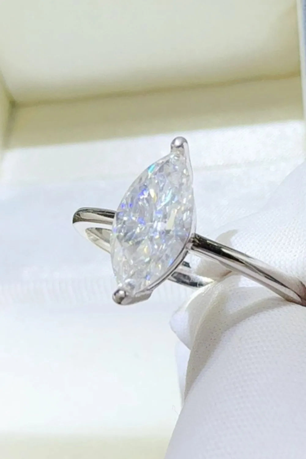 "Serenata Marquise 2 Carat Moissanite Solitaire Ring in platinum-plated 925 sterling silver with elongated marquise cut stone on prong setting."