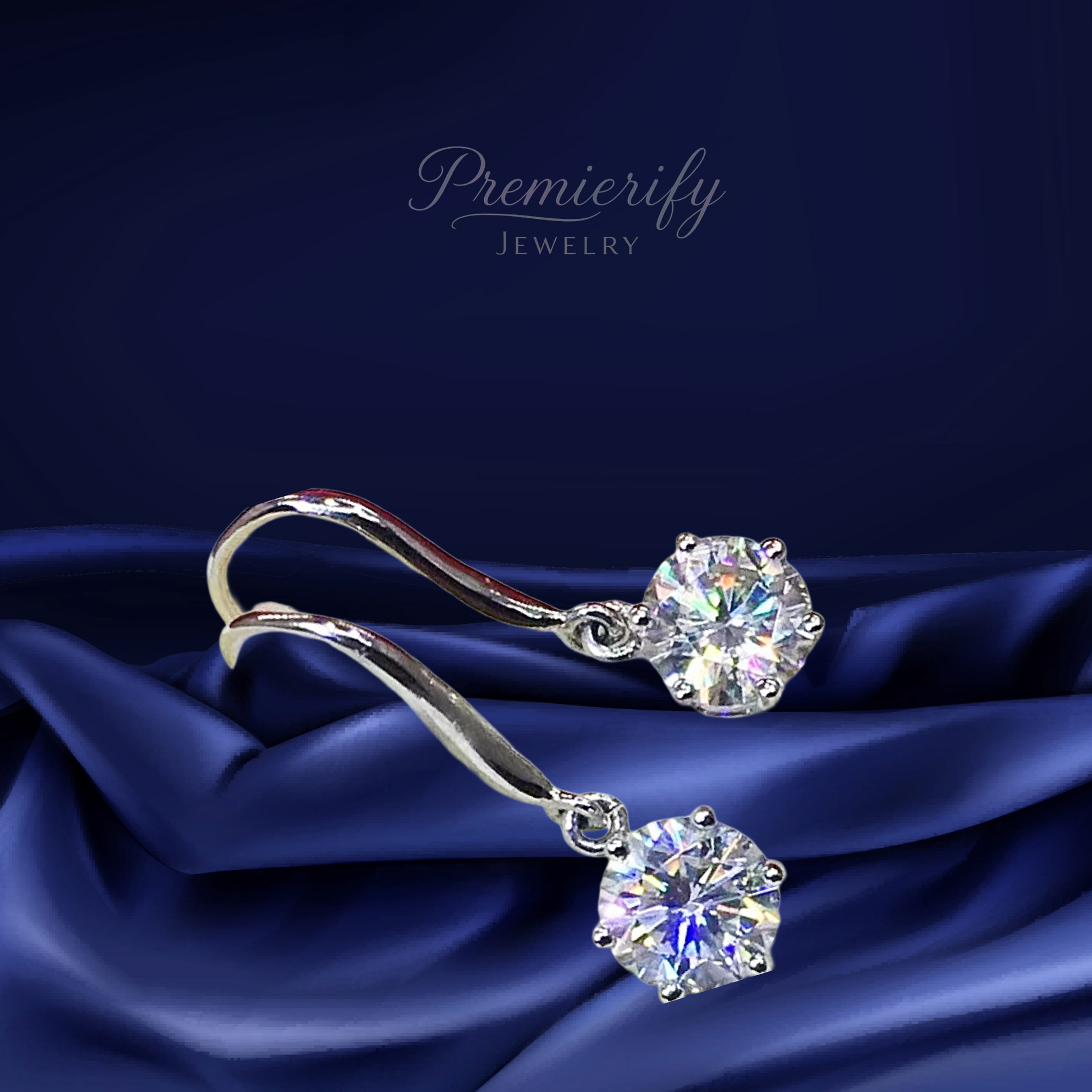 Silver earrings with large gemstones on a blue satin background, featuring the brand 'Premierify Jewelry'.