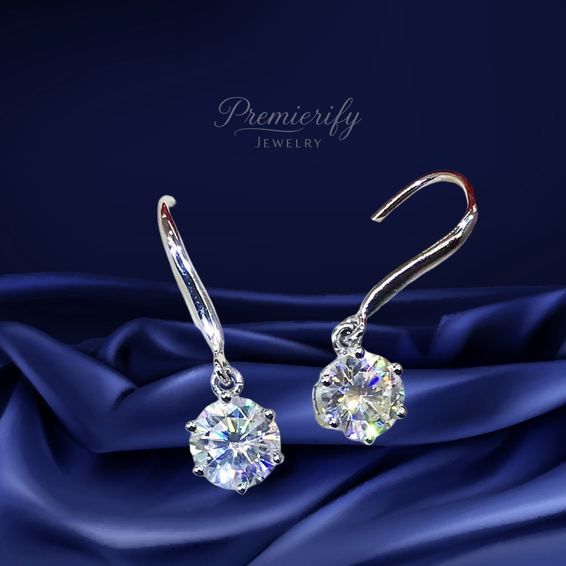 Silver earrings with round gemstones on a dark blue satin background, featuring the brand 'Premierify Jewelry'.