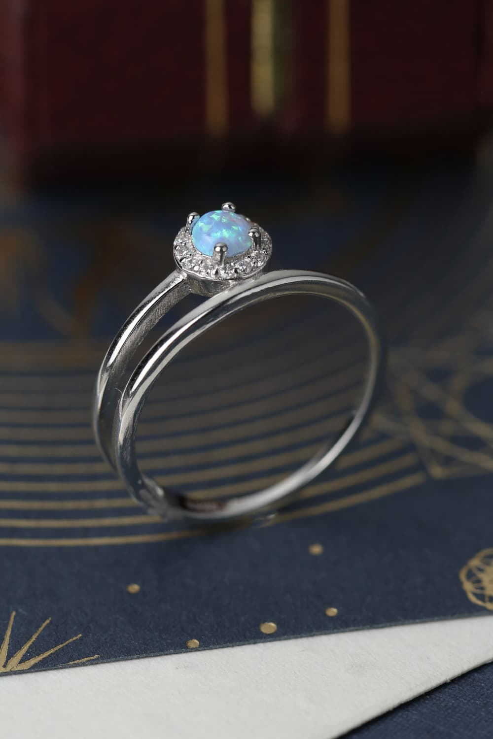 Side profile of a white opal solitaire showing prongs and gallery detail.