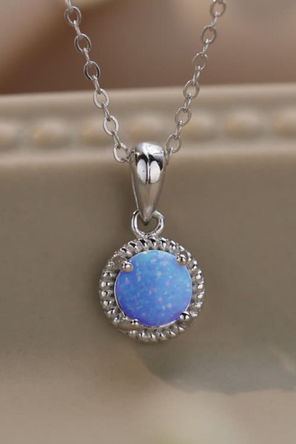 blue opal pendant on tan background