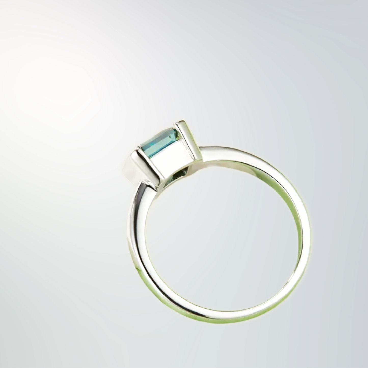 Side view of bezel-set 1 ct sea-glass green moissanite ring in platinum-plated 925 sterling silver.
