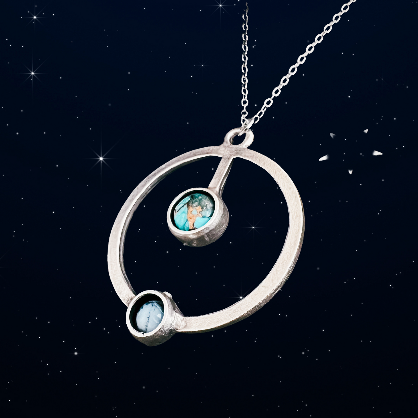 Silver necklace with circular pendant against a starry night sky background