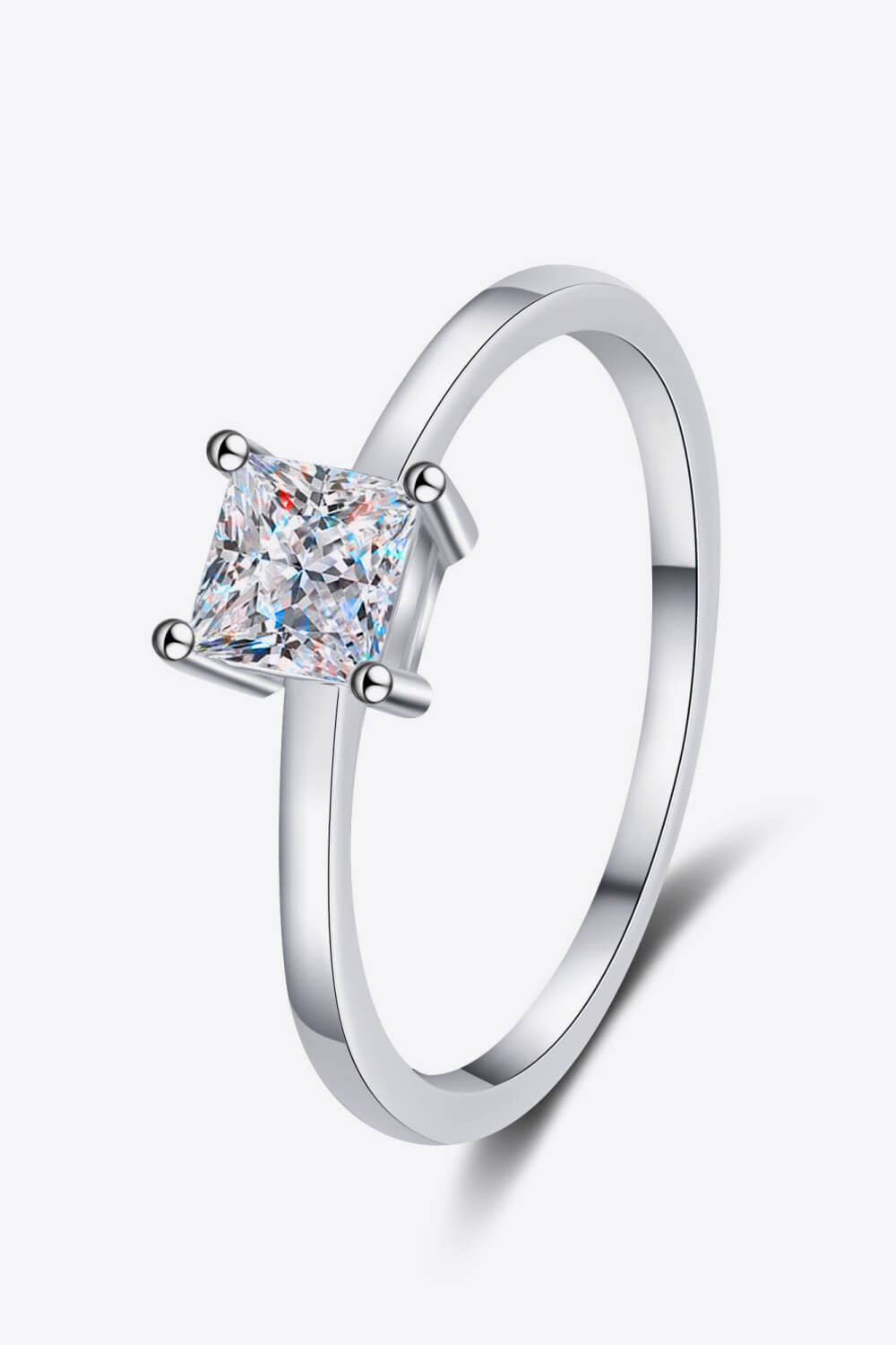 Auren™ princess-cut moissanite solitaire ring in platinum-plated 925 sterling silver with minimalist band, styled in modern chic photography.