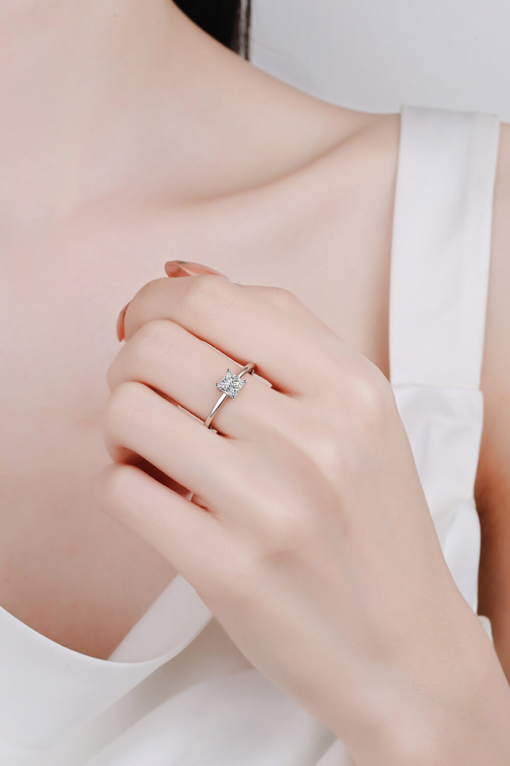 Person wearing princess cut ring.