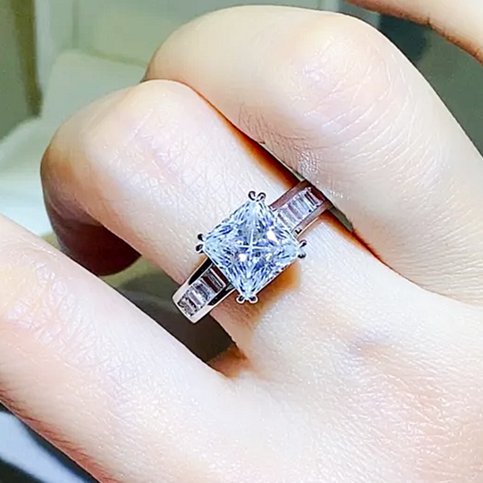 Diamond ring on a finger with a blurred background