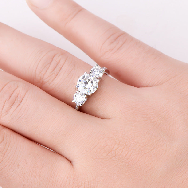 Eterna Trio™ 3 Carat Moissanite Ring in platinum-plated 925 sterling silver featuring three round-cut stones symbolizing past, present, and future.