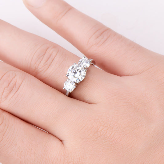 Eterna Trio™ 3 Carat Moissanite Ring in platinum-plated 925 sterling silver featuring three round-cut stones symbolizing past, present, and future.