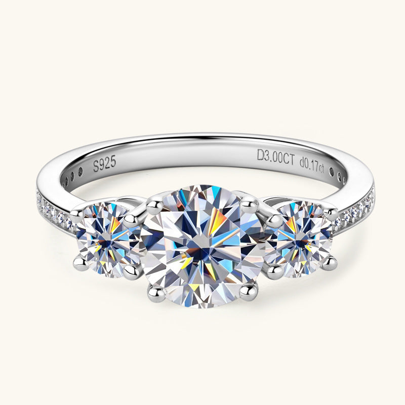 Eterna Trio™ 3 Carat Moissanite Ring in platinum-plated 925 sterling silver featuring three round-cut stones symbolizing past, present, and future.