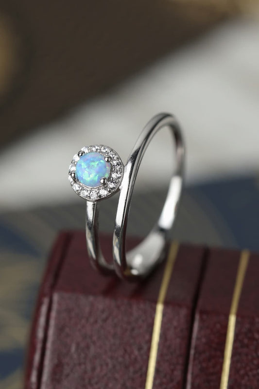 Side profile of a white opal solitaire showing prongs and gallery detail.
