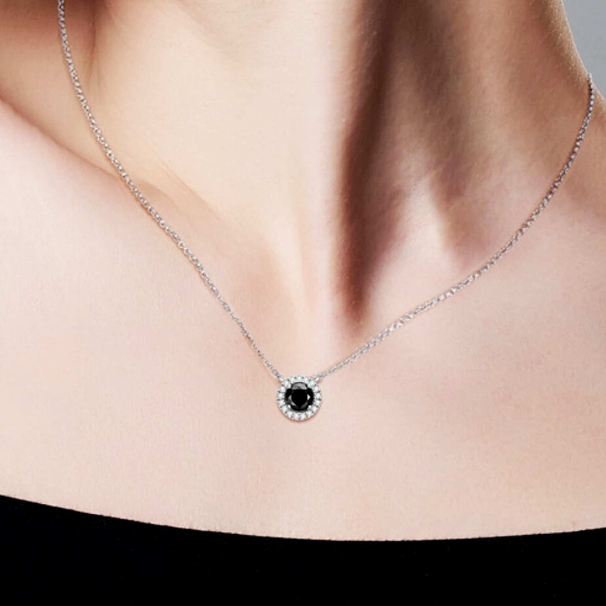 Necklace with a black gemstone worn by a person
