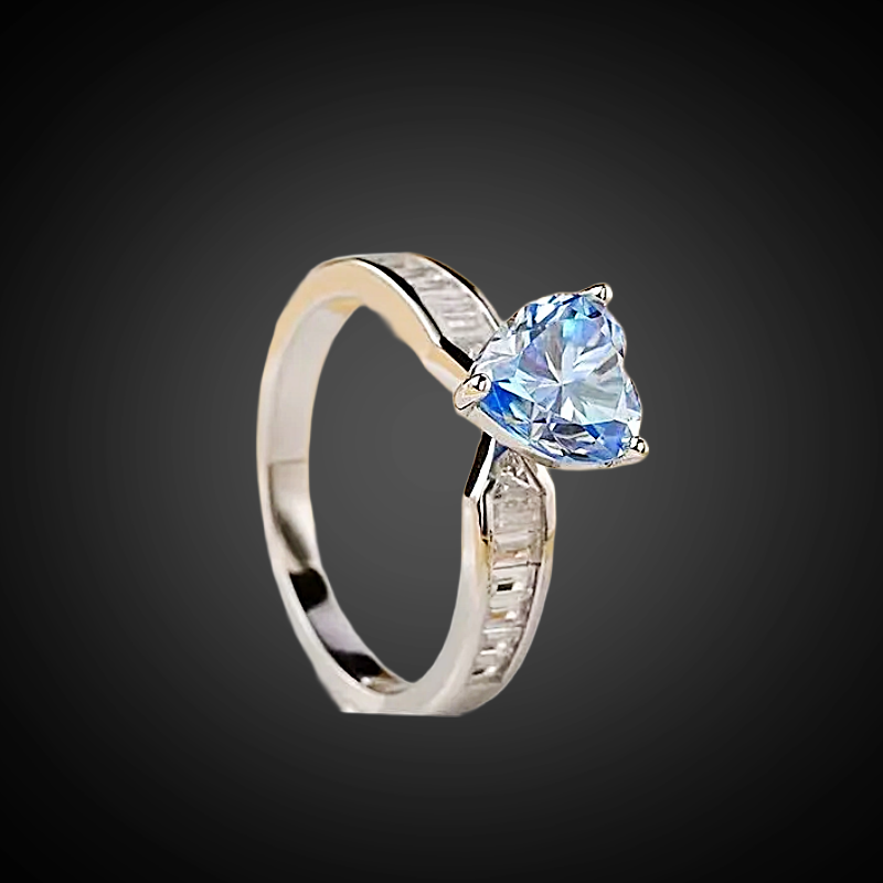 Silver ring with a heart-shaped blue gemstone on a black background