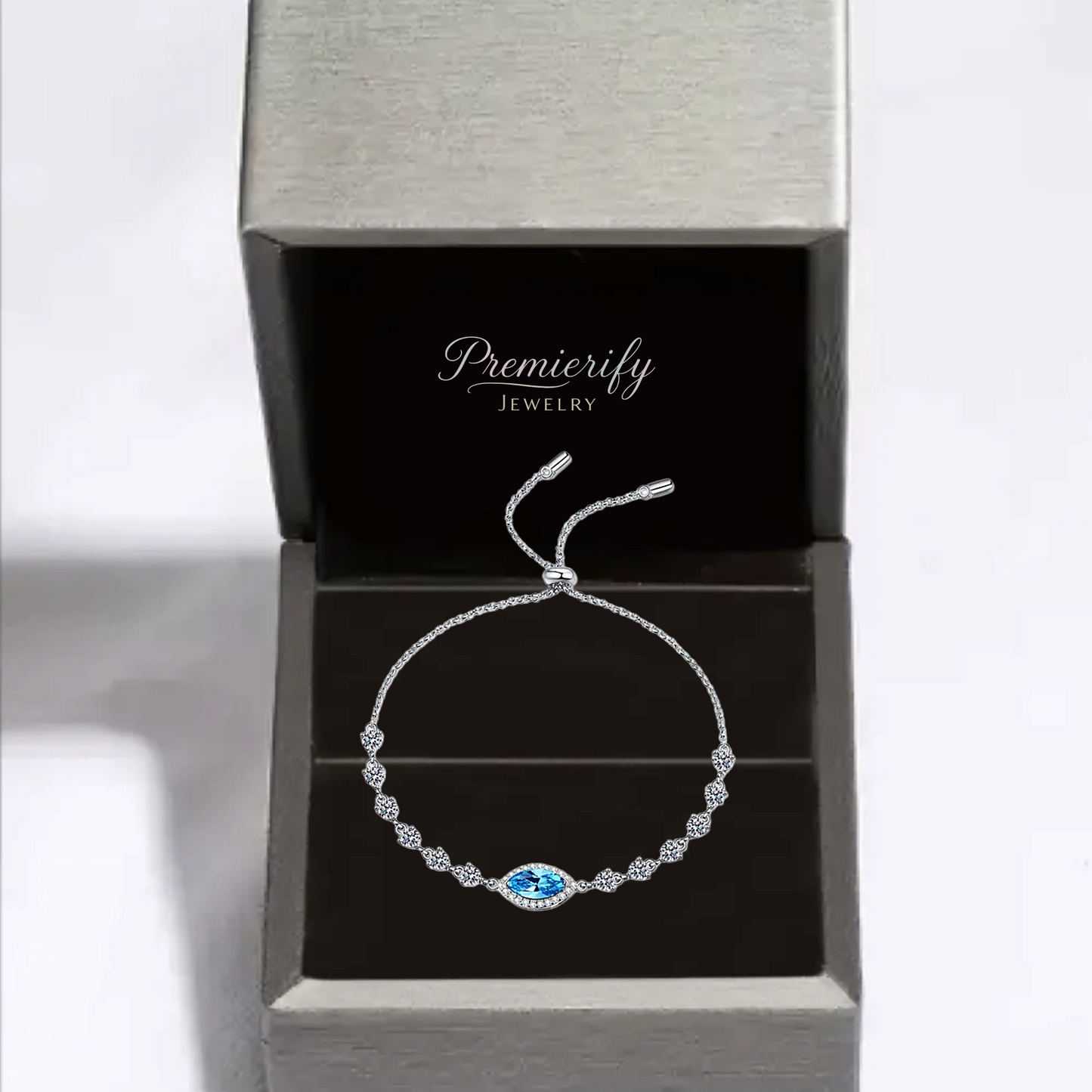 Silver bracelet with a blue gemstone in an open jewelry box labeled 'Premierify Jewelry'.