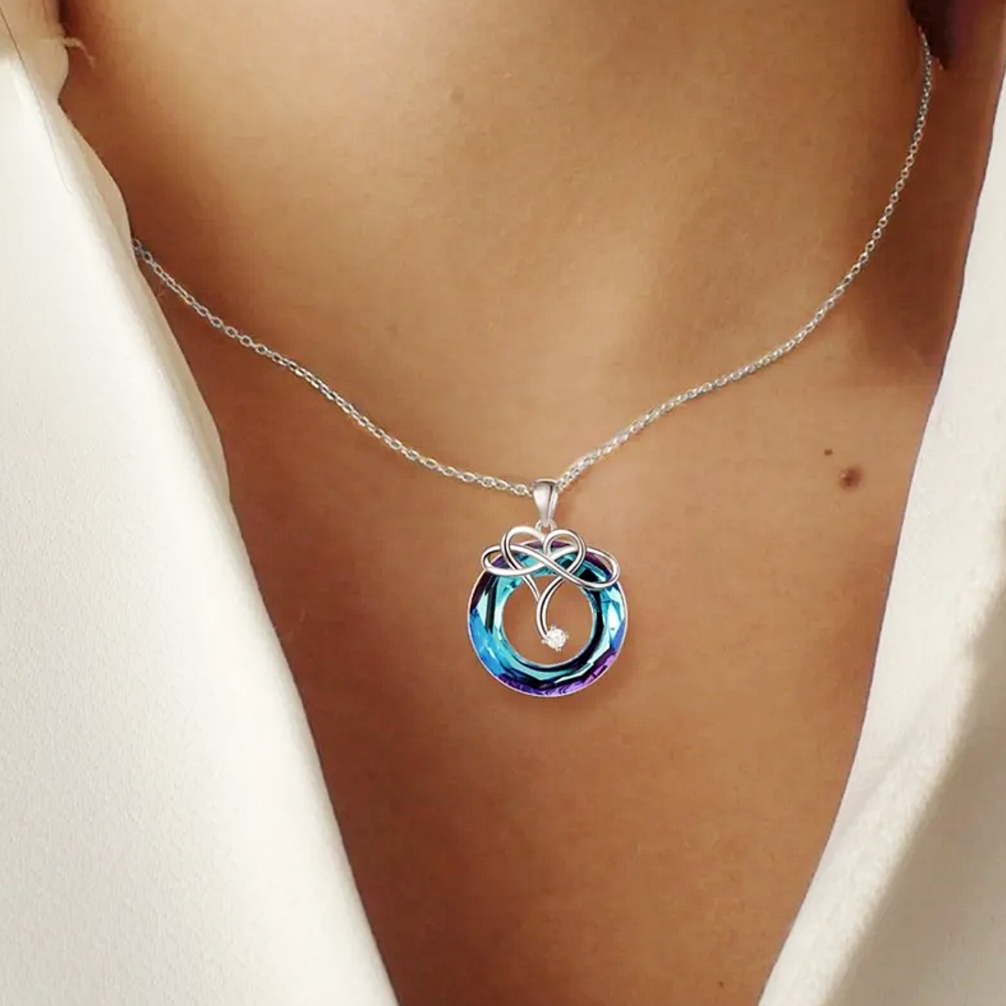 Necklace with a colorful pendant on a person wearing a white top