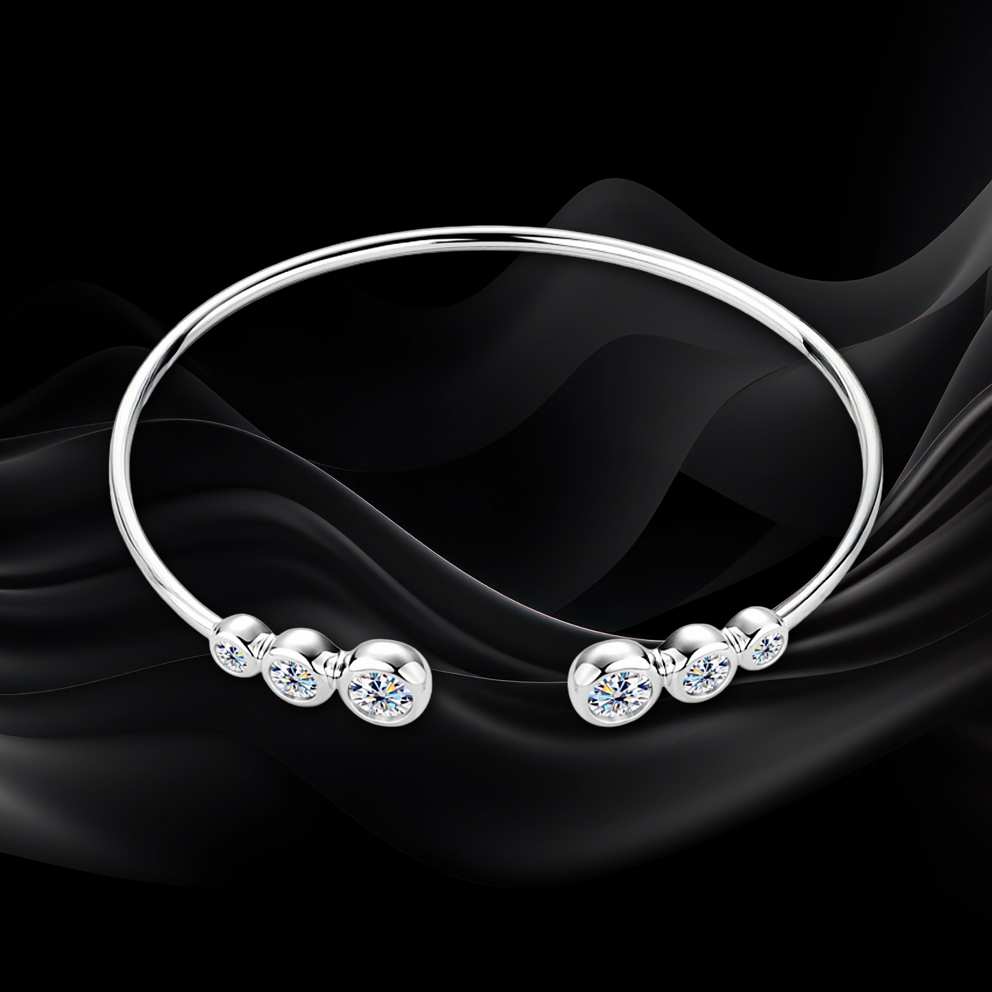 Silver bracelet with round embellishments on a black fabric background