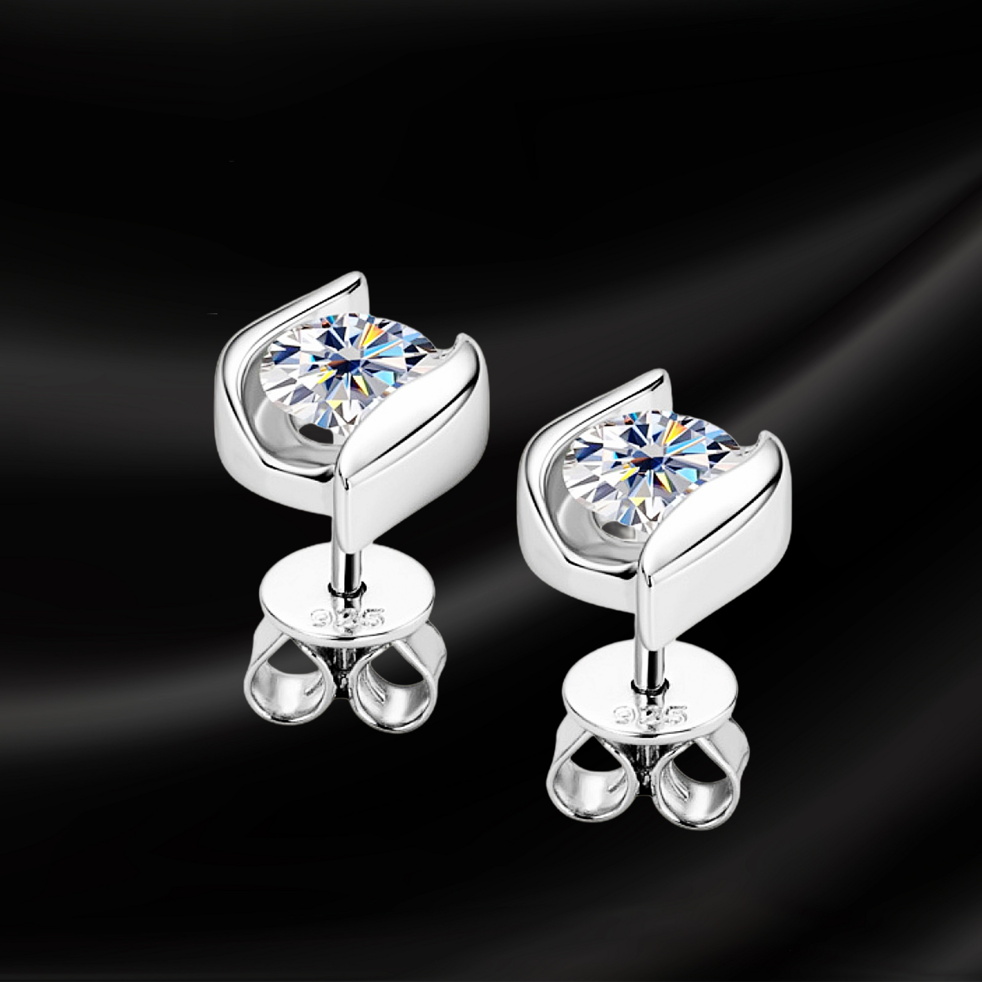 Silver earrings with clear gemstones on a black background