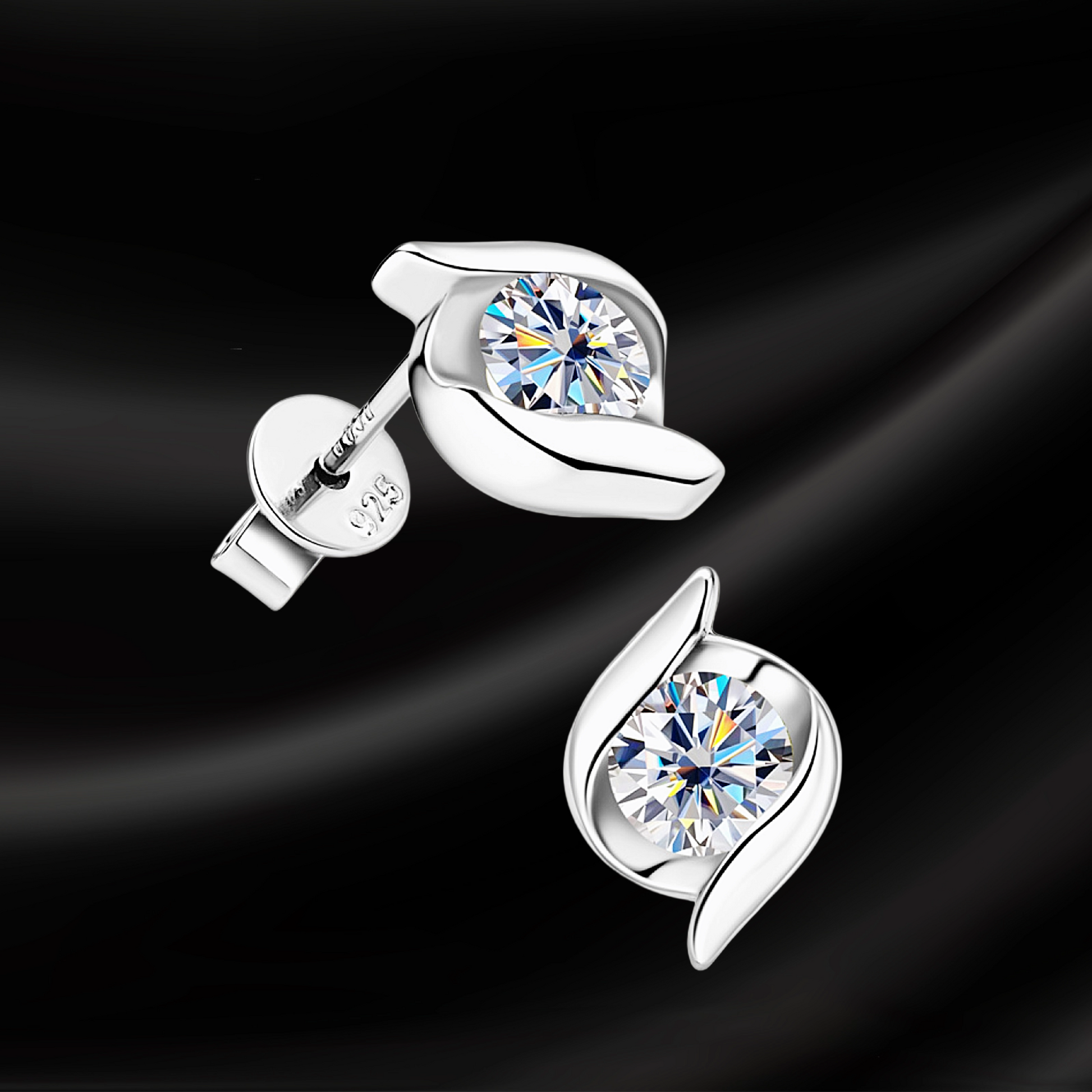 Silver earrings with clear gemstones on a black background