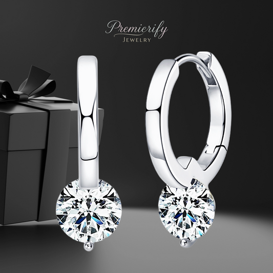 Silver hoop earrings with clear gemstones in front of a gift box, branded 'Premierify Jewelry'.