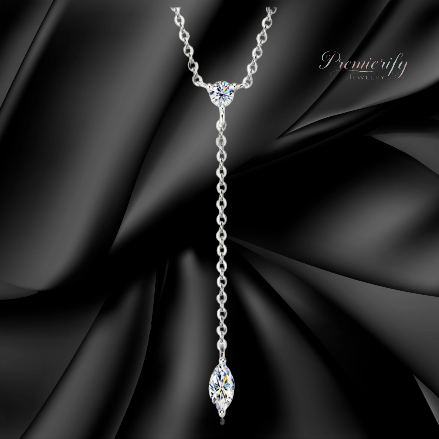Silver necklace with a marquise-shaped pendant on a black fabric background