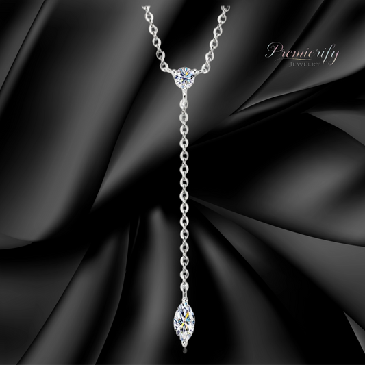 Silver necklace with a marquise-shaped pendant on a black fabric background