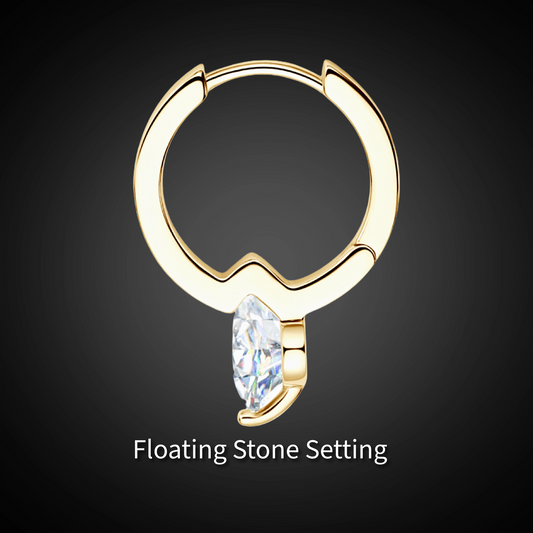 Gold hoop earring with a floating stone on a dark background