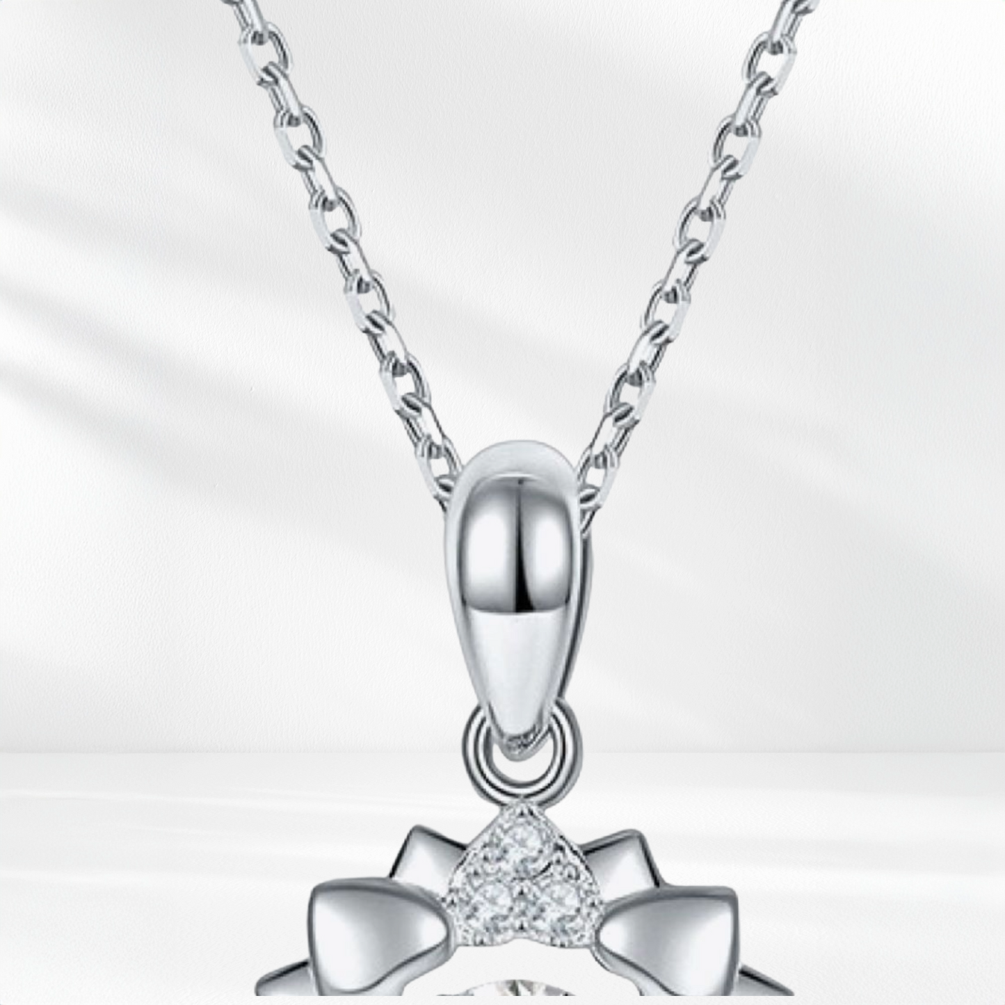 Silver necklace with a heart-shaped pendant on a light gray background