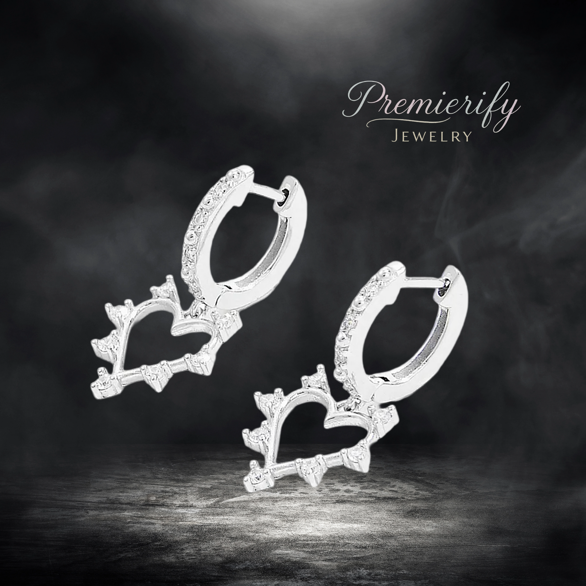 Heart-shaped silver earrings with sparkling stones on a dark background, featuring the 'Premierify Jewelry' brand.
