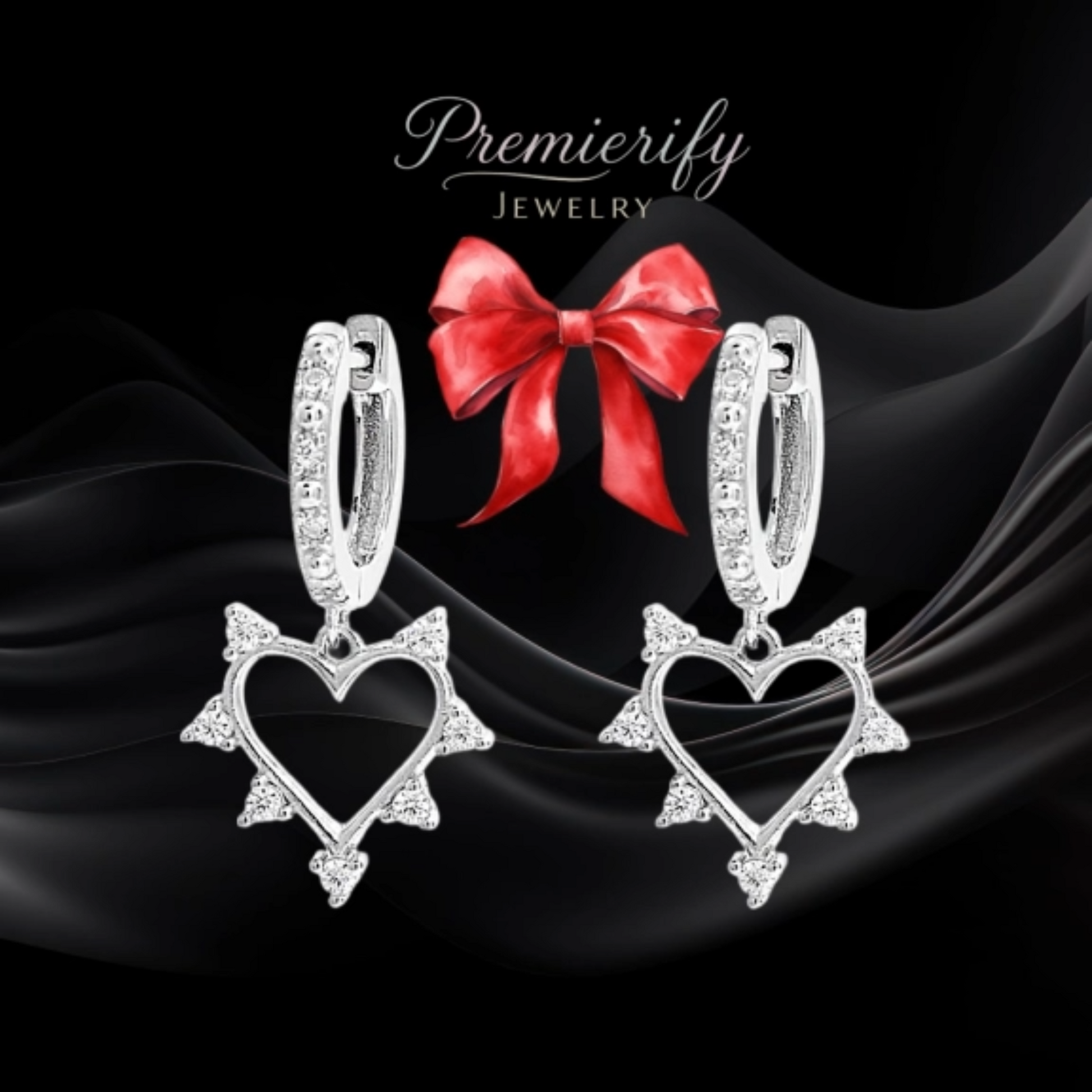 Heart-shaped earrings with a red bow on black fabric, featuring the brand 'Premierify Jewelry'.