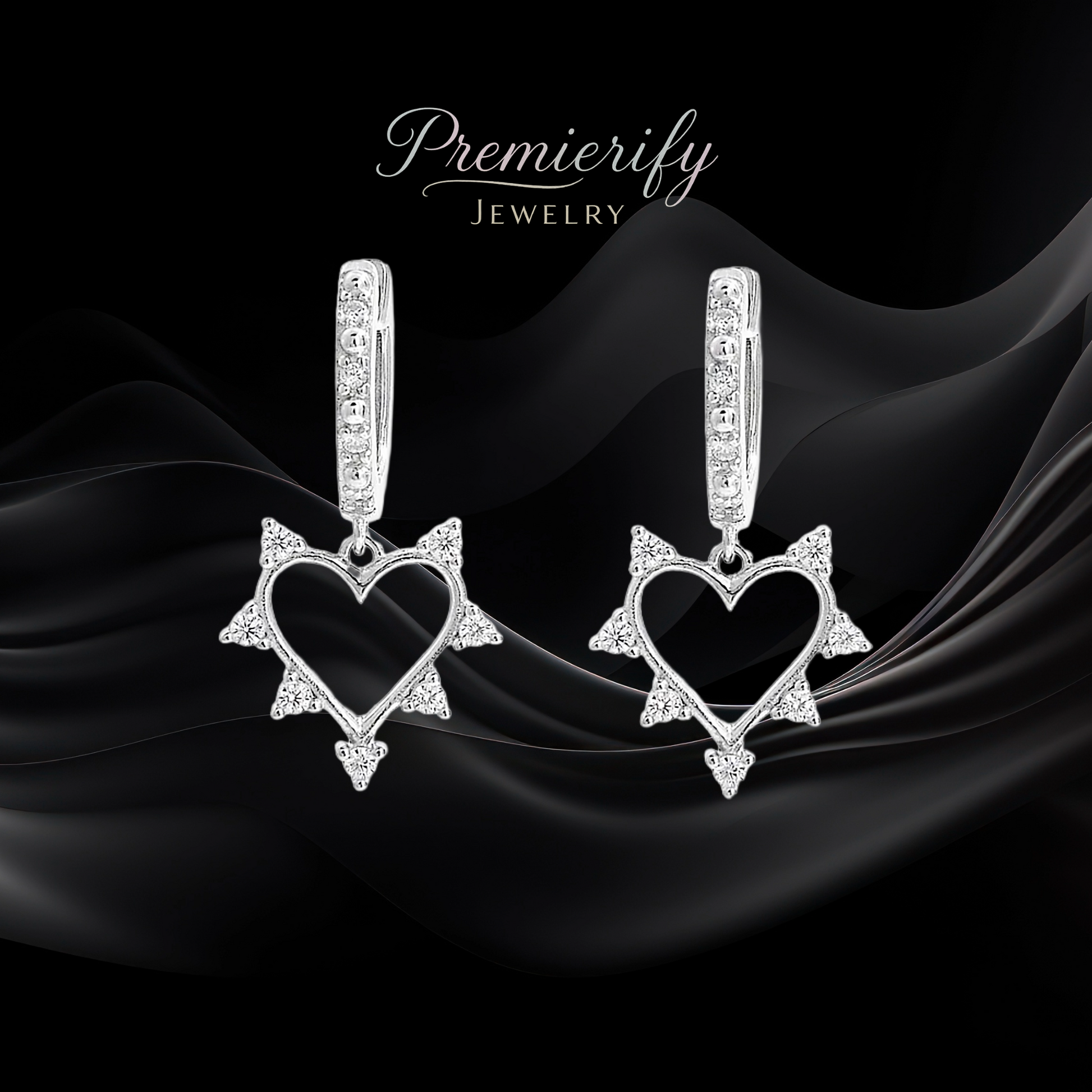 Heart-shaped earrings on black fabric with 'Premierify Jewelry' branding.