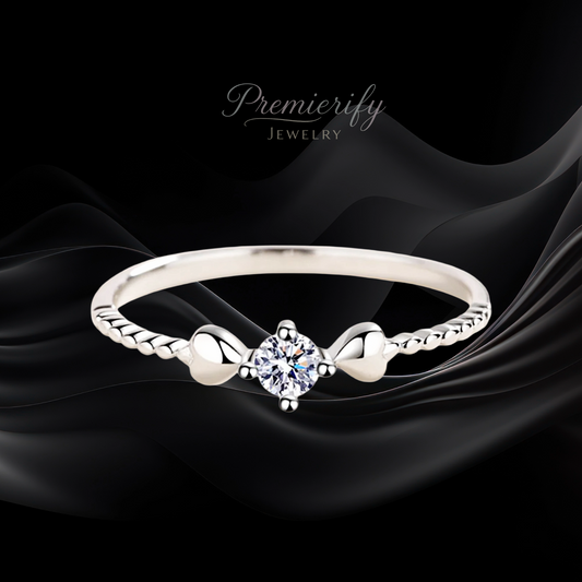 Silver ring with a diamond on a black fabric background, featuring the brand 'Premierify Jewelry'.