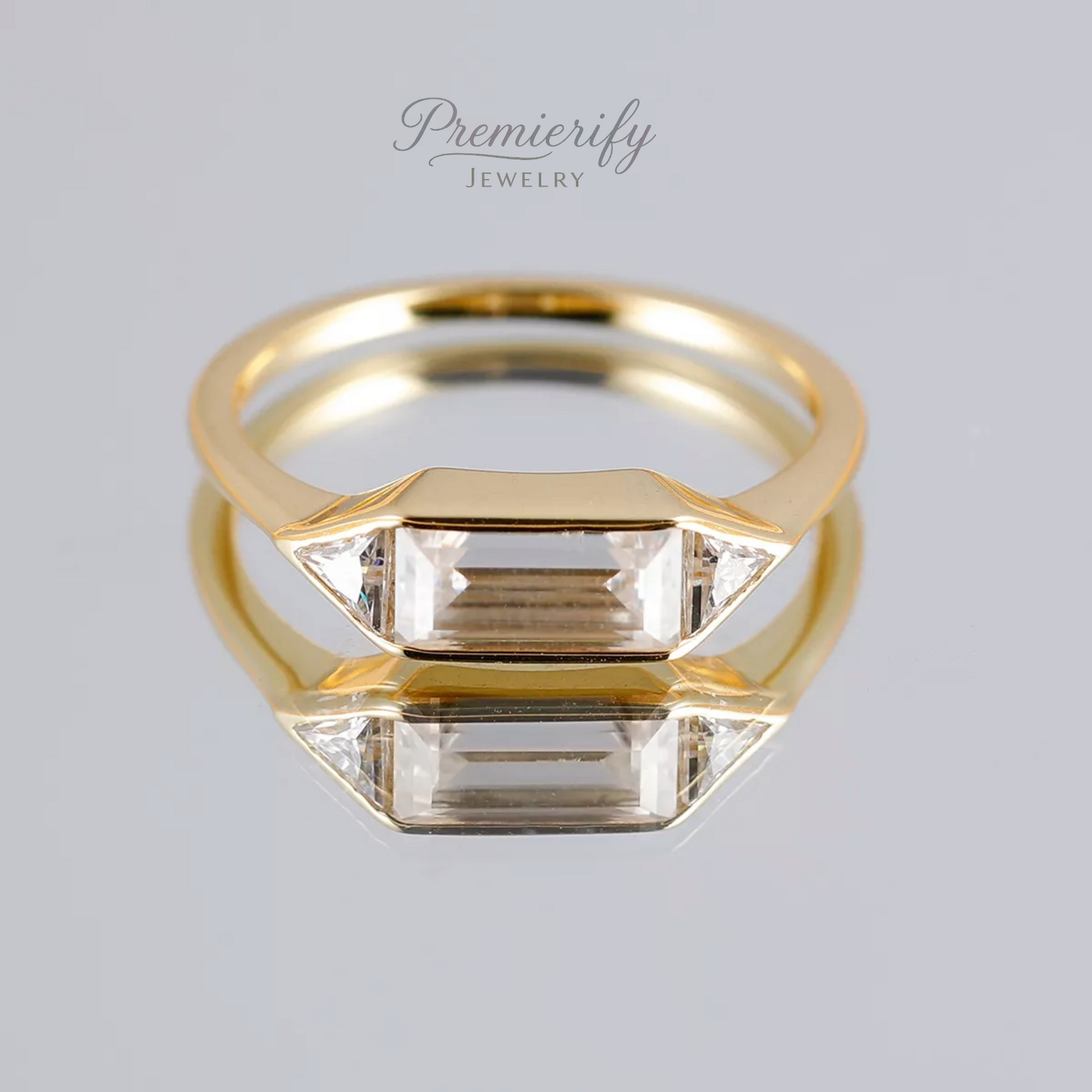 Gold ring with a clear gemstone on a light gray background, branded 'Premierify Jewelry'.