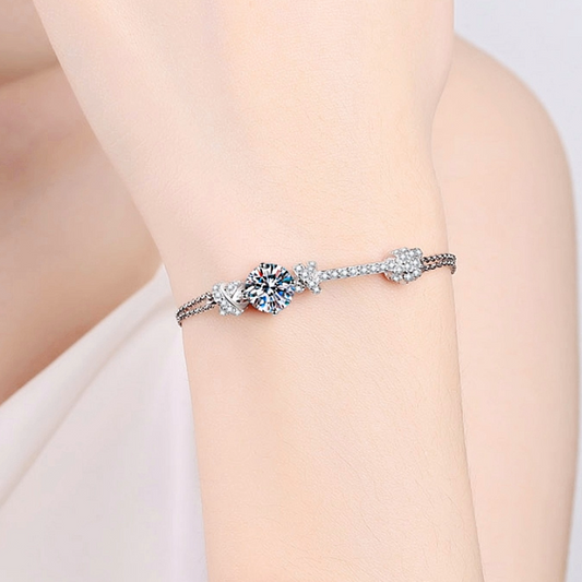 Silver bracelet with a floral design on a person's wrist against a light background