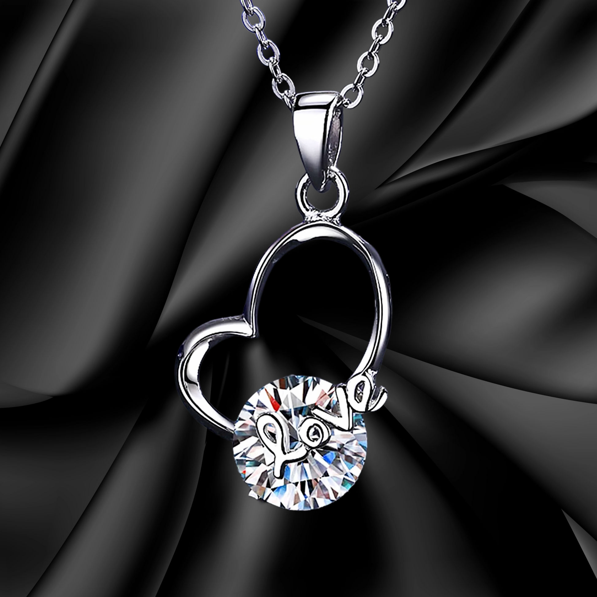 Silver necklace with a heart and 'love' pendant on a black background