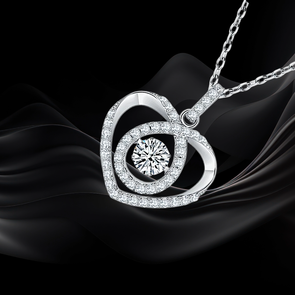 Silver necklace with a heart-shaped pendant on black fabric