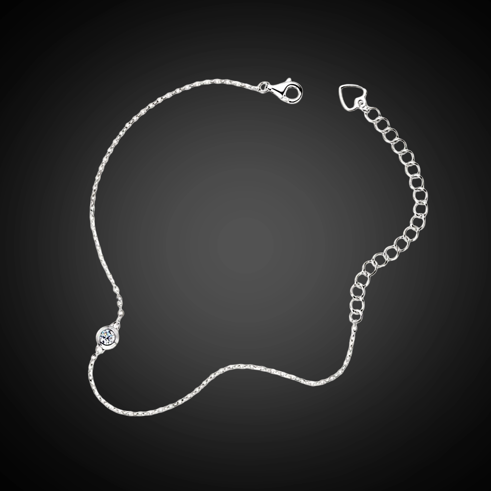 Silver bracelet with a small diamond on a dark background