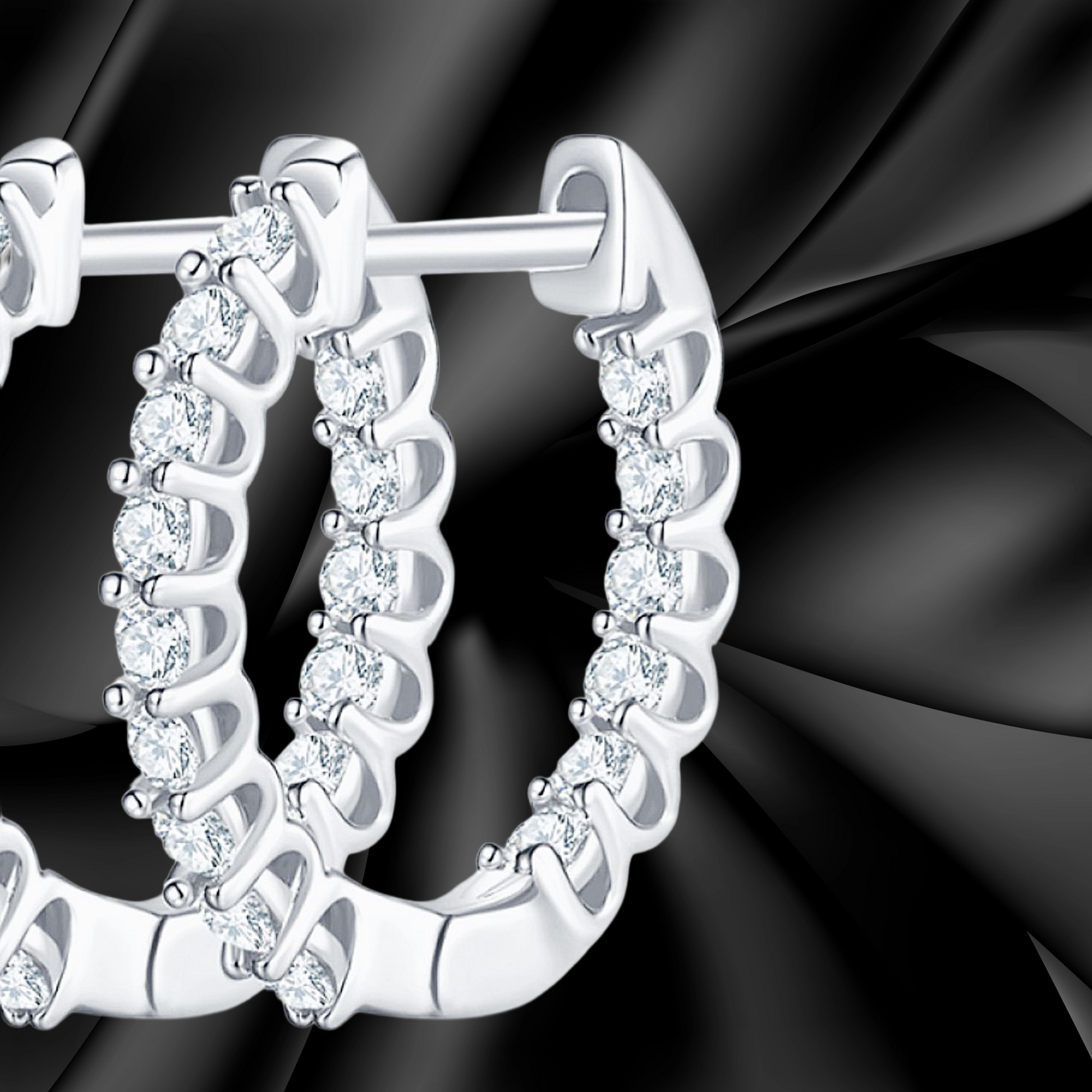 Silver hoop earrings with clear gemstones on a black background