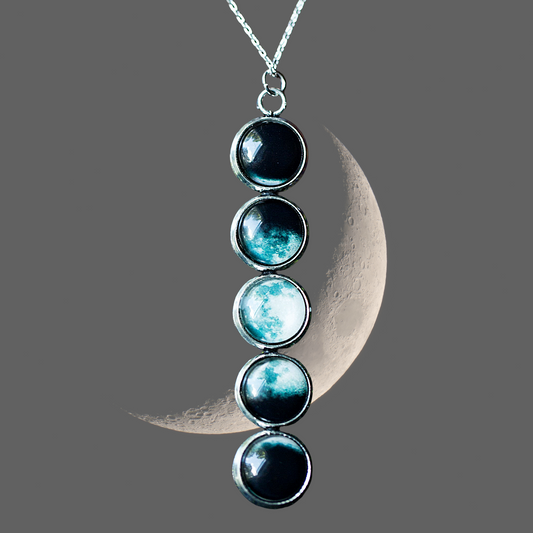 Necklace with a crescent moon and four gemstones on a gray background