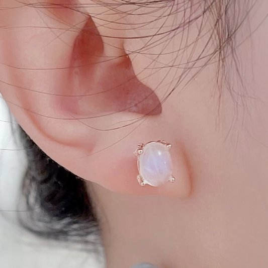 Close-up of an ear wearing a delicate earring with a soft focus background