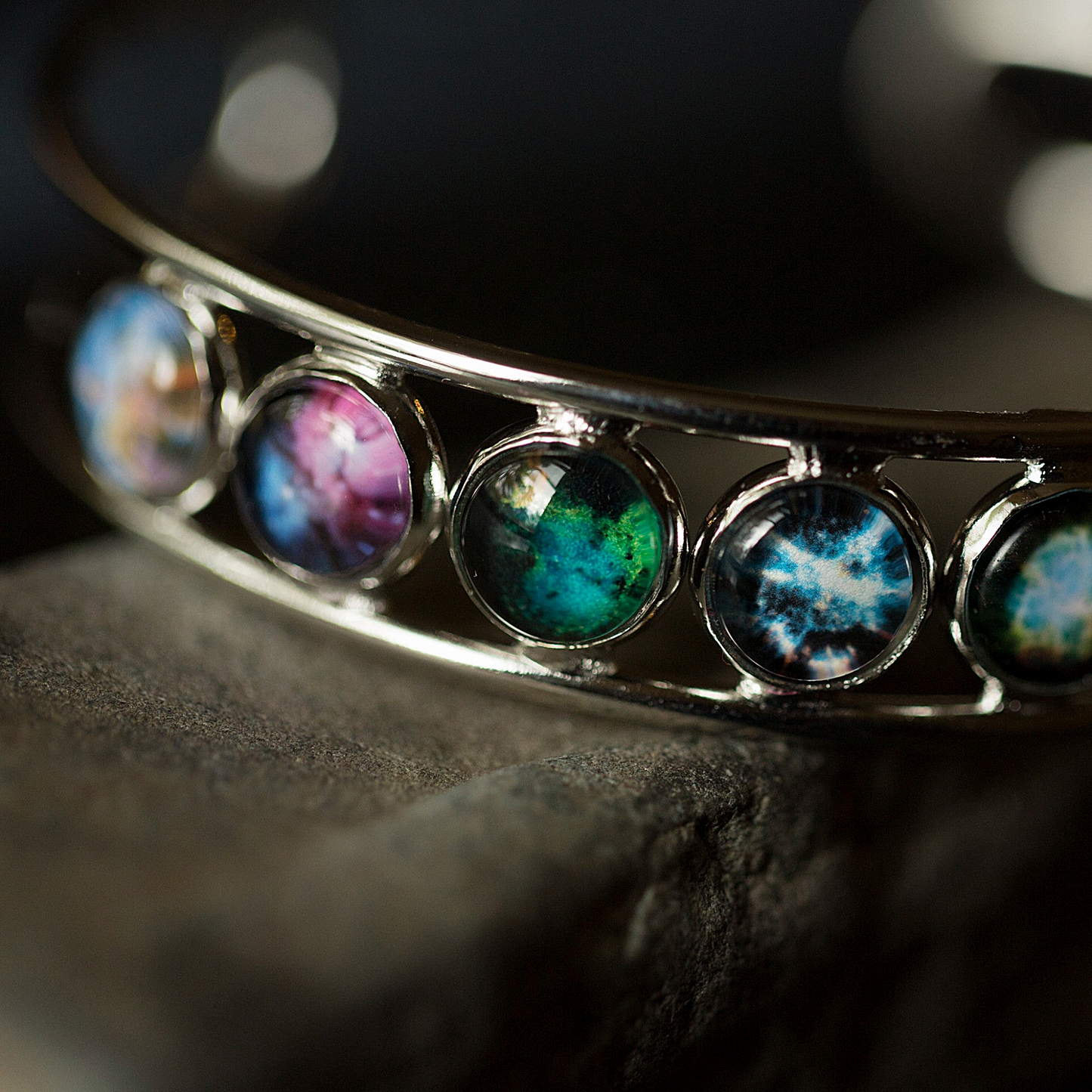 Close-up of a bracelet with colorful gemstones on a dark background