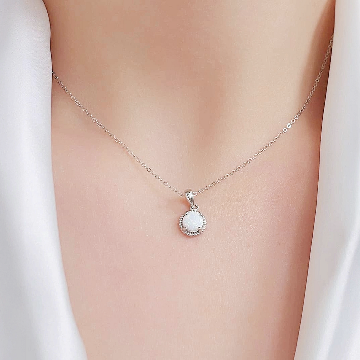 Necklace with a pendant on a person wearing a white garment