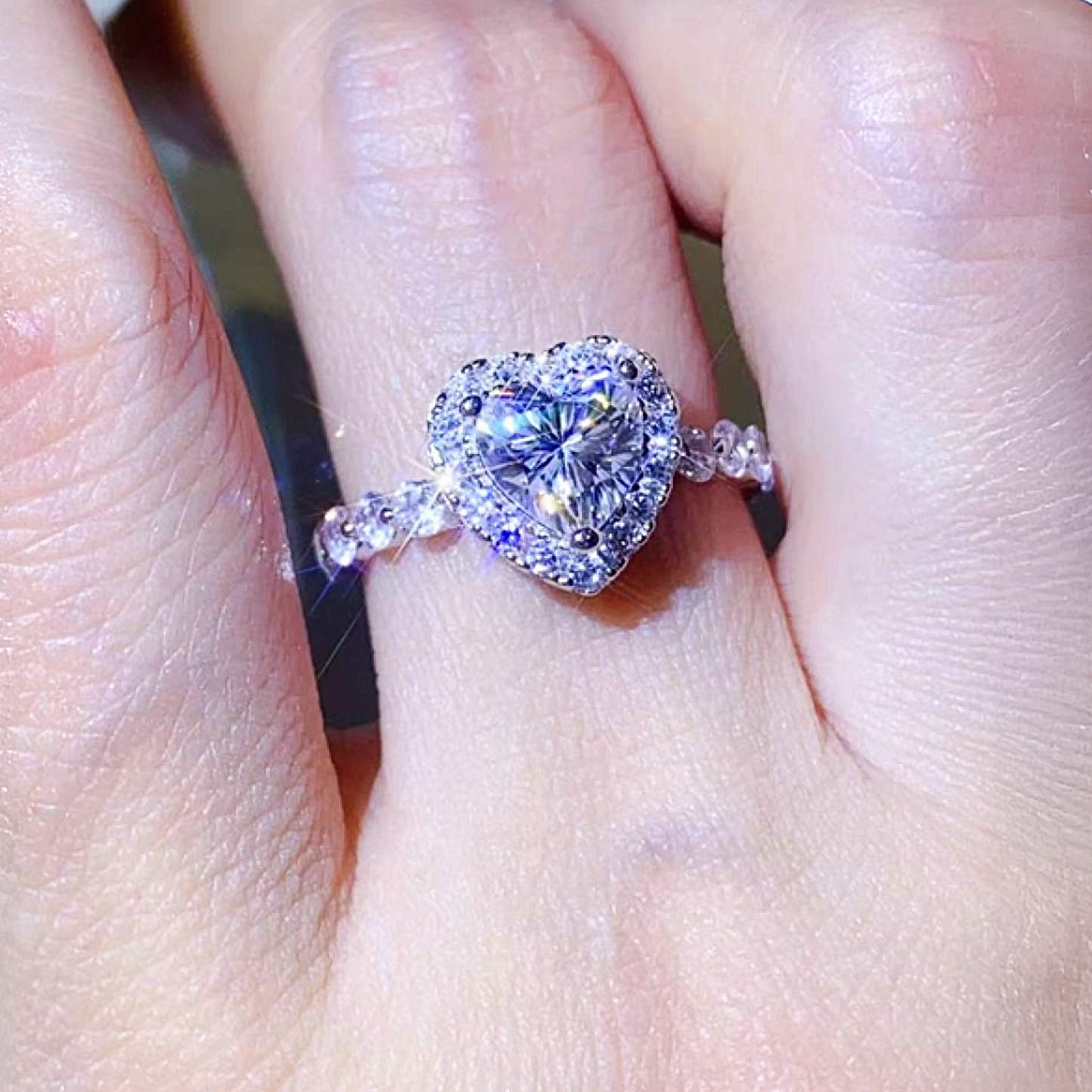 Heart-shaped diamond ring on a finger