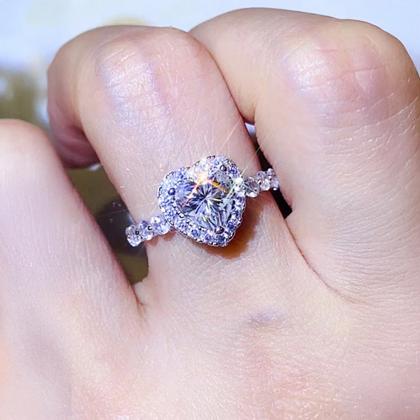 Diamond ring on a finger with a blurred background
